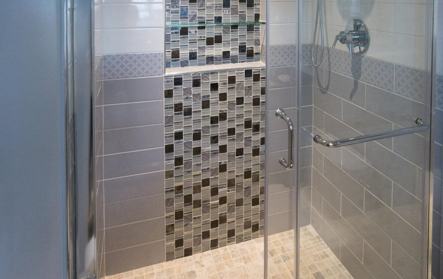 a glass shower door in a tiled bathroom