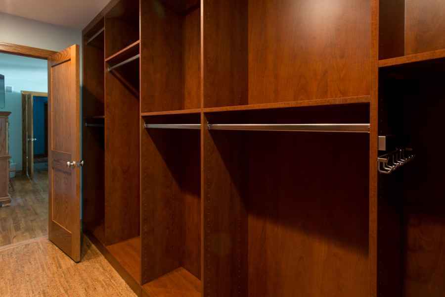 an empty walk in closet with wooden shelves