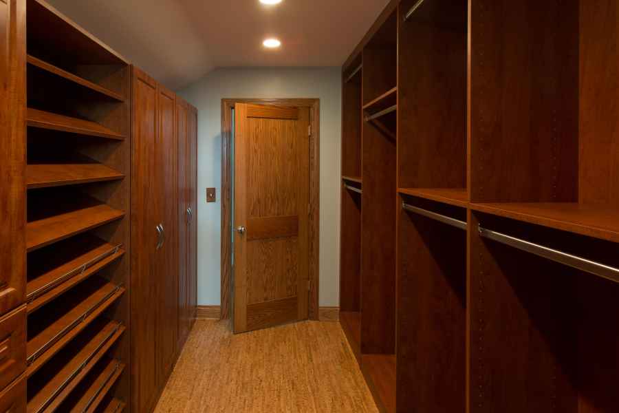 a walk in closet filled with lots of wooden shelves