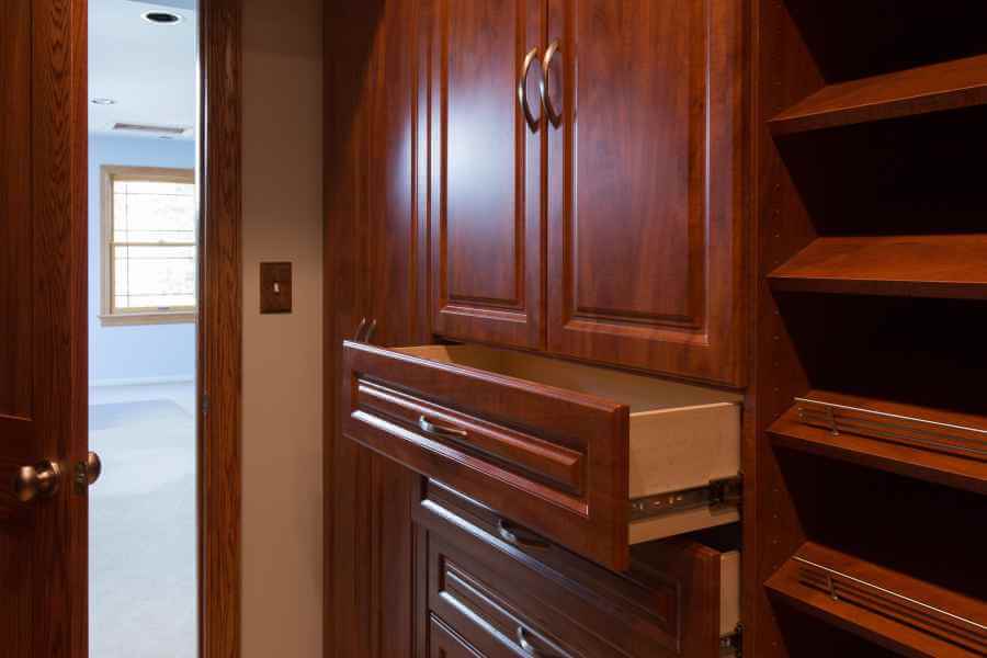 a closet with wooden cabinets and drawers