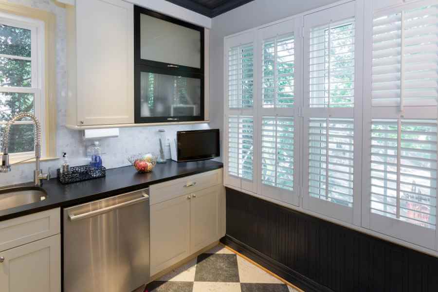 a kitchen with white cabinets and black counter tops