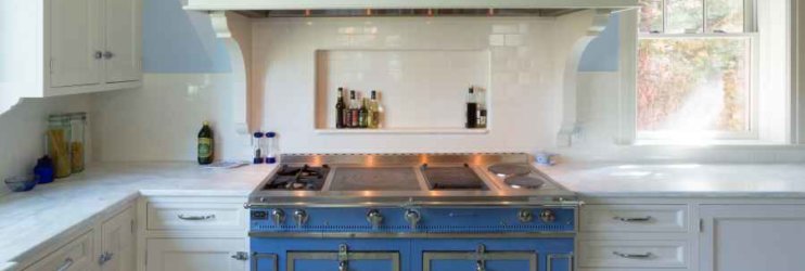 a blue stove top oven sitting inside of a kitchen