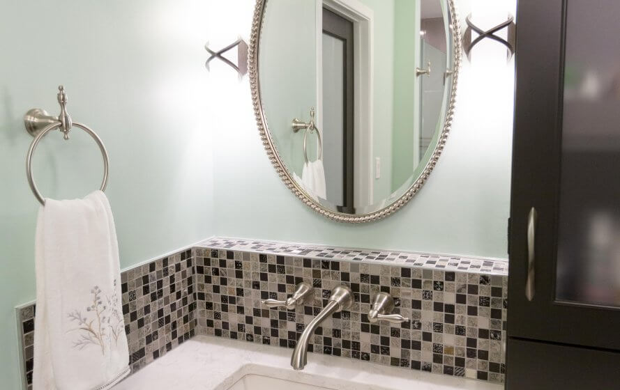 a bathroom with a sink, mirror and towel rack
