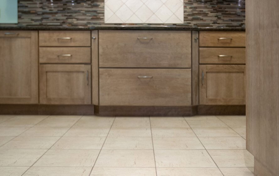 a kitchen with wooden cabinets and tile flooring