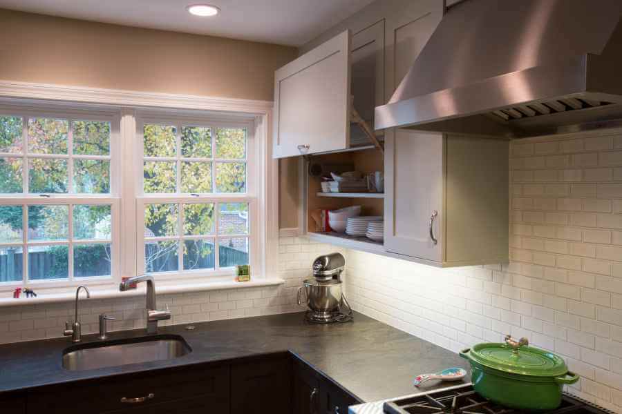 a kitchen with a stove top oven next to a window