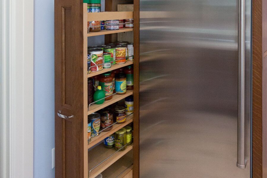 Hidden spice rack pulled out next to refrigerator