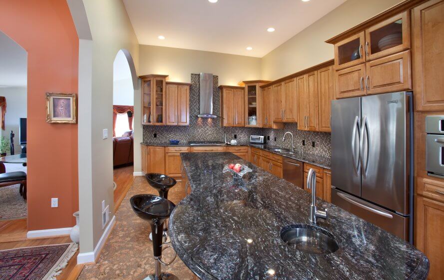 a kitchen with granite counter tops and wooden cabinets