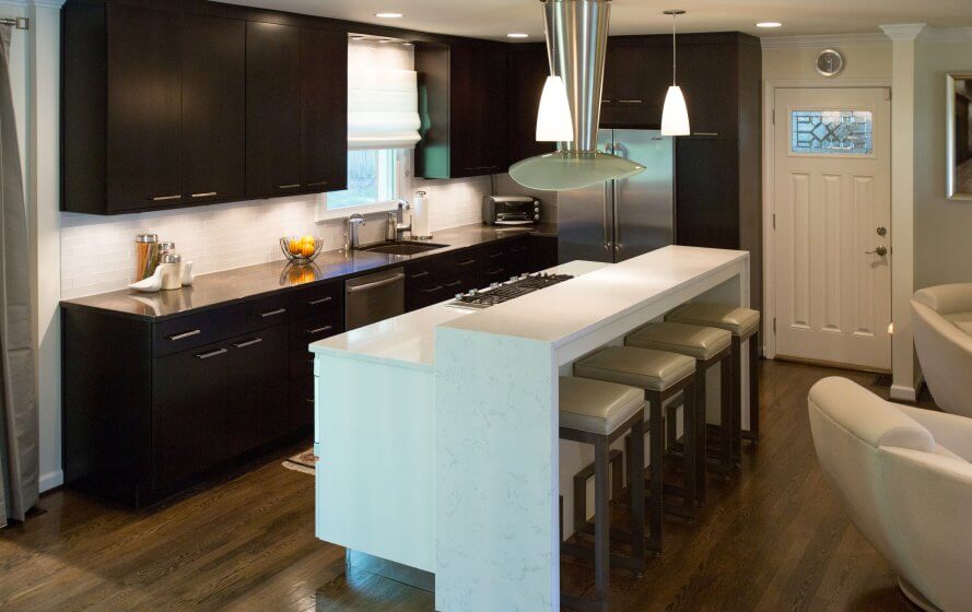 a modern kitchen with black cabinets and white counter tops