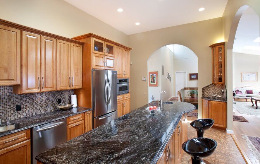 a kitchen with granite counter tops and wooden cabinets