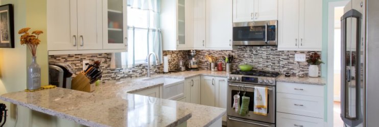 Kitchen remodel with white cabinets and light stone countertops