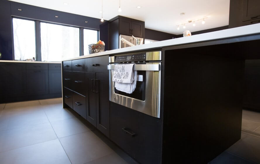 a kitchen with black cabinets and white counter tops