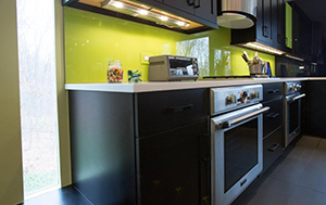 a kitchen with black cabinets and green walls