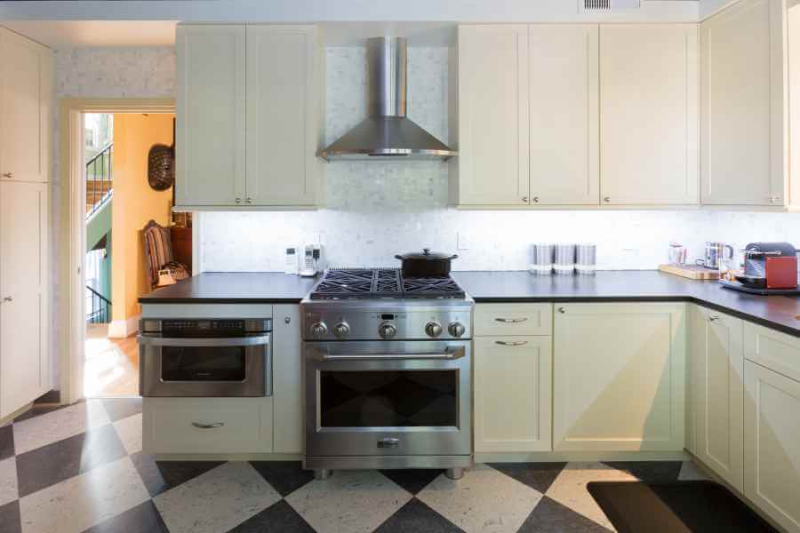 a kitchen with an oven, stove and checkered floor