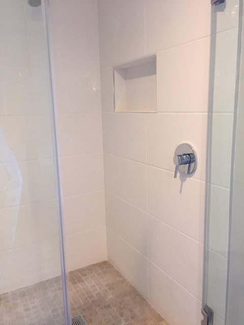 a bathroom with a shower and tiled floor