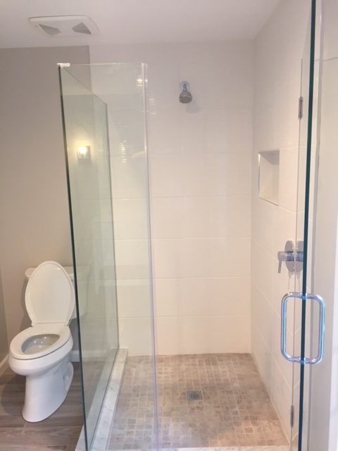 a bathroom with a glass shower door and toilet