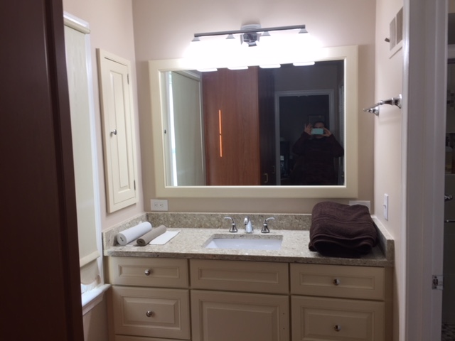 a bathroom with large vanity with one sink and a large mirror in Silver Spring MD