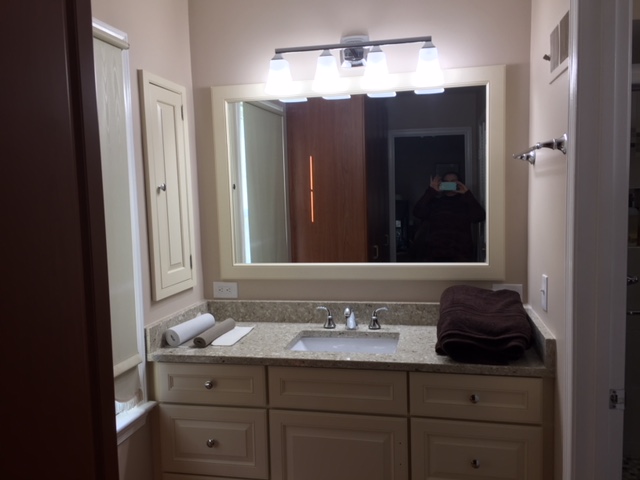 a bathroom with large vanity with one sink and a large mirror in Silver Spring MD