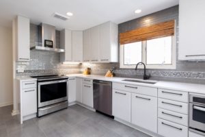 Kitchen remodel with white cabinets and stainless steel appliances.