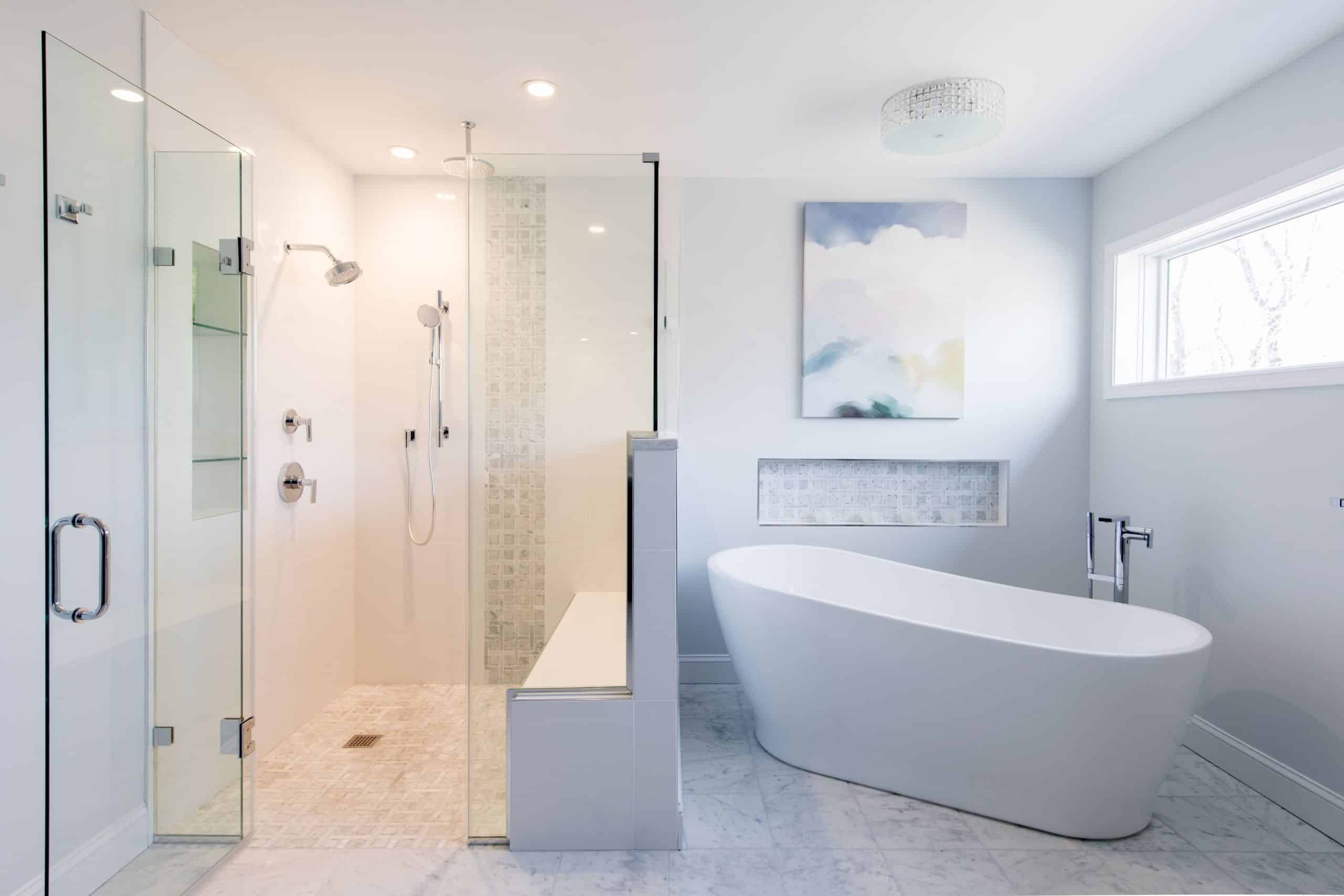 a modern bathroom with bright bathtub and glass shower with bench