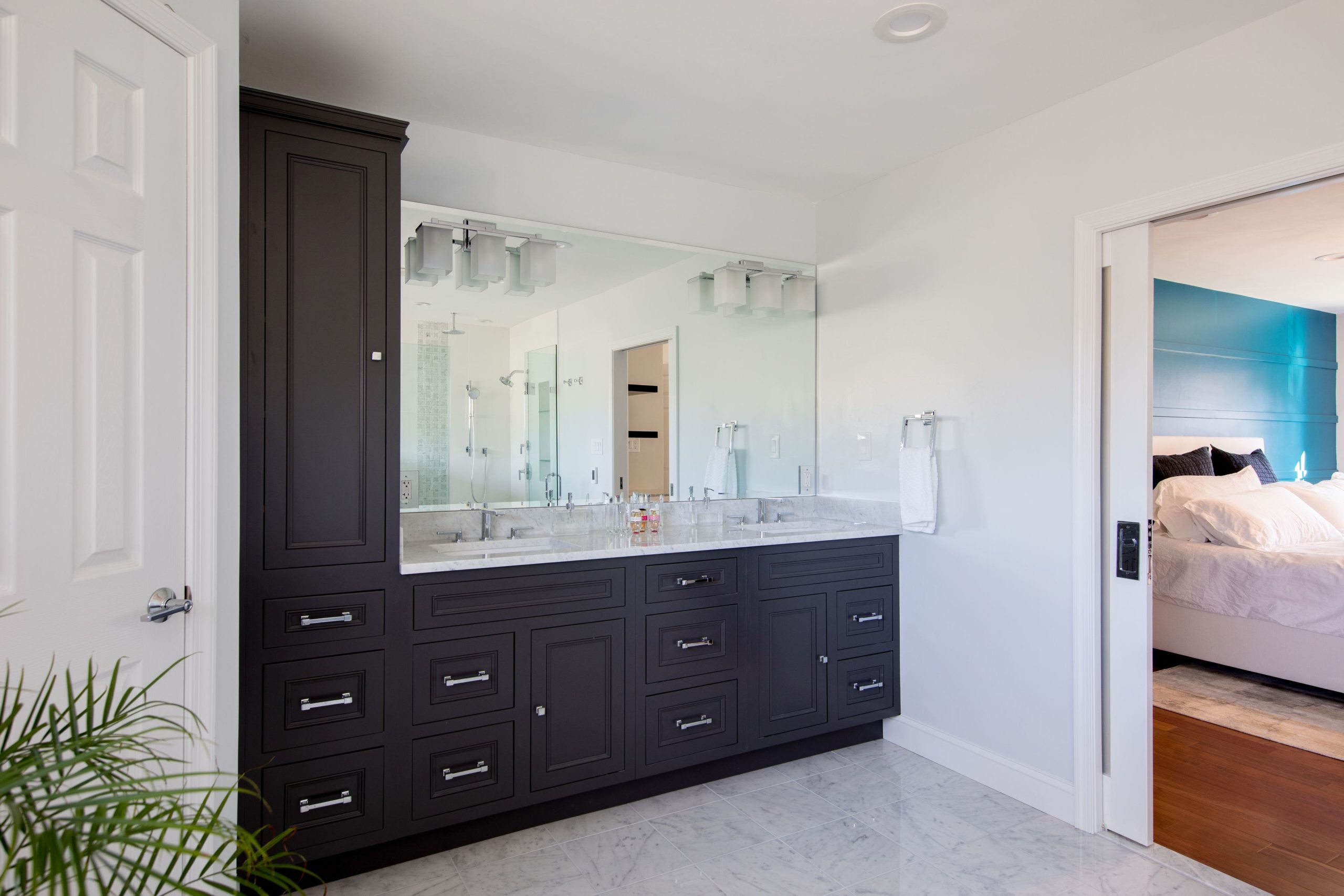 a bathroom with a large mirror, double sinks, and many wooden cabinets