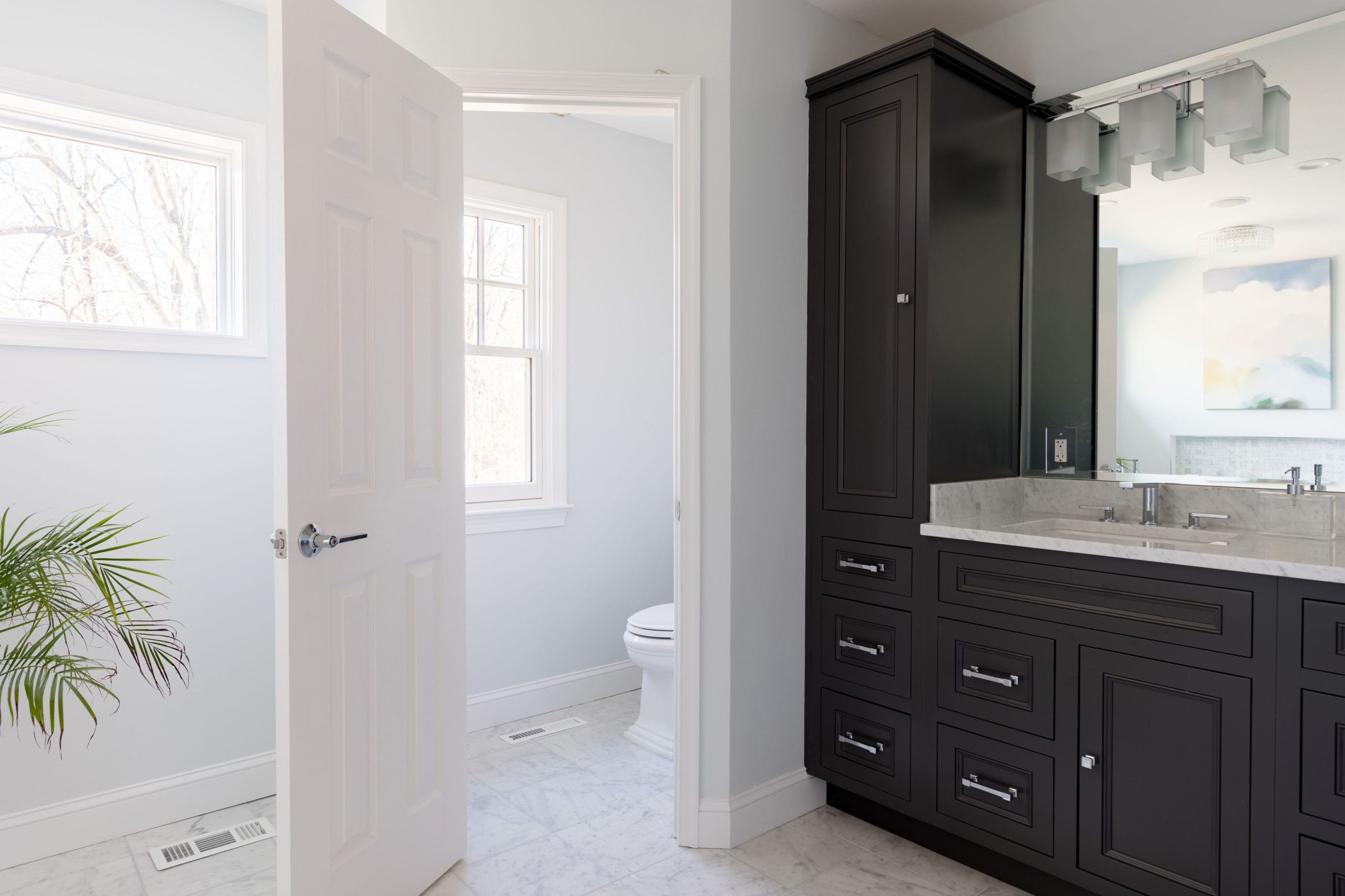 a bathroom with a large mirror and black cabinets
