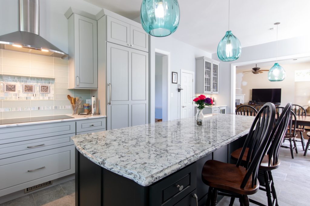 Kitchen island with hanging pendant lights in a newly renovated kitchen.