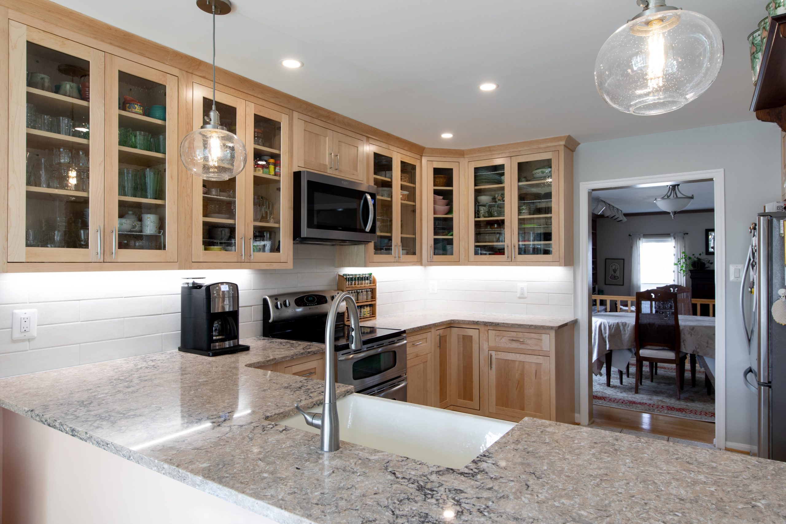 a kitchen with wooden cabinets and marble counter tops