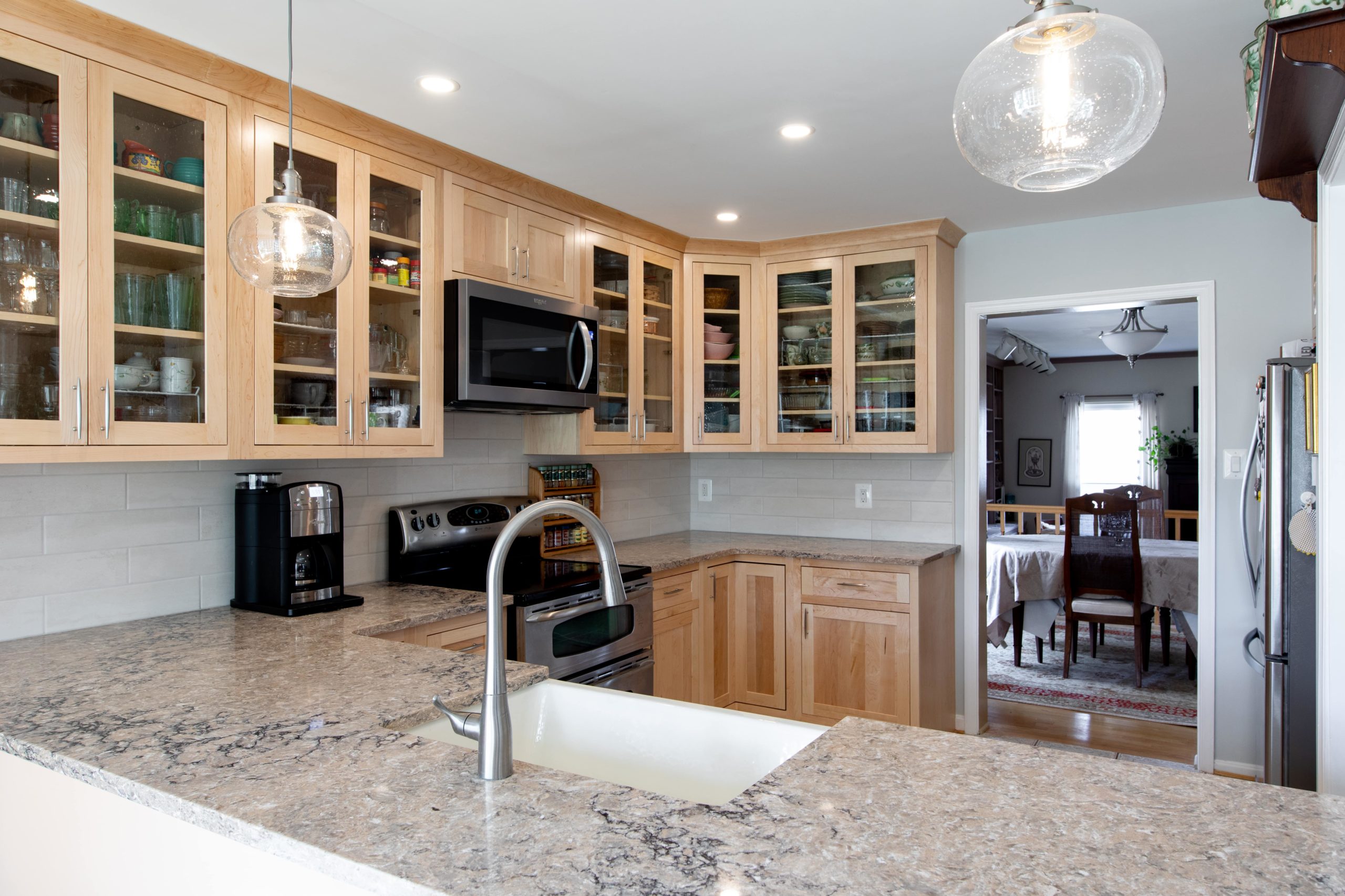 a kitchen with wooden cabinets and marble counter tops