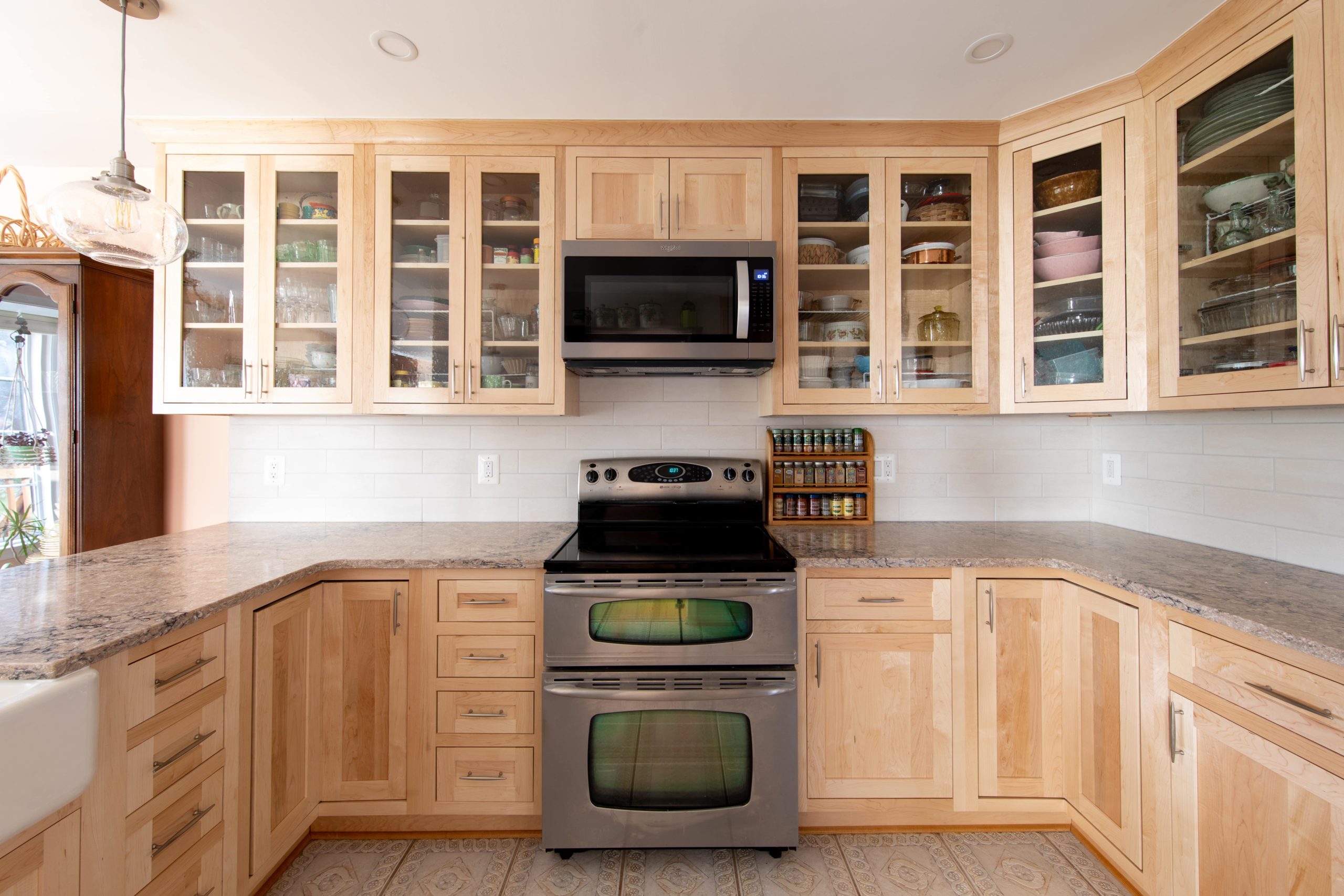 a kitchen with light wooden cabinets and stainless steel appliances
