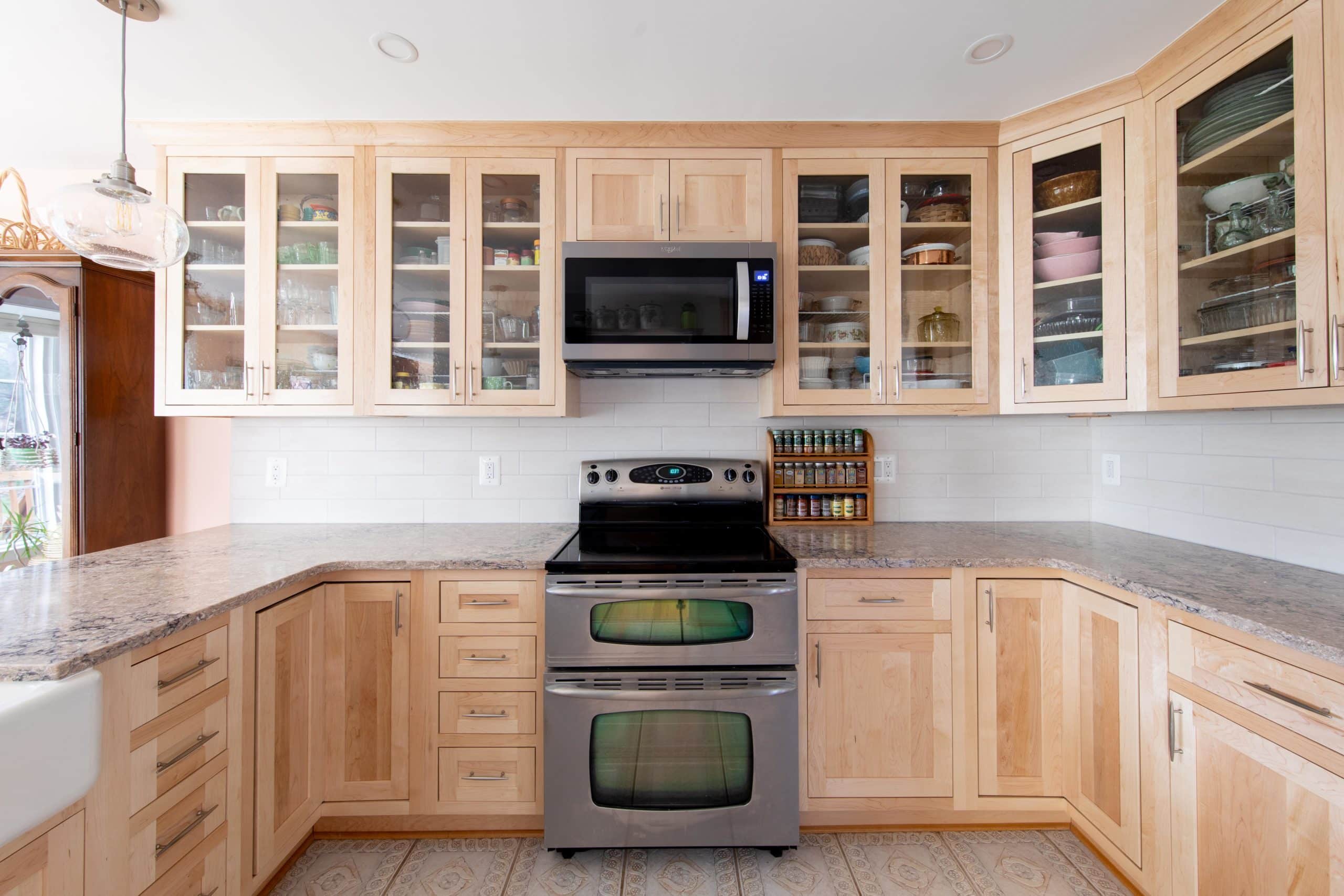 a kitchen with light wooden cabinets and stainless steel appliances