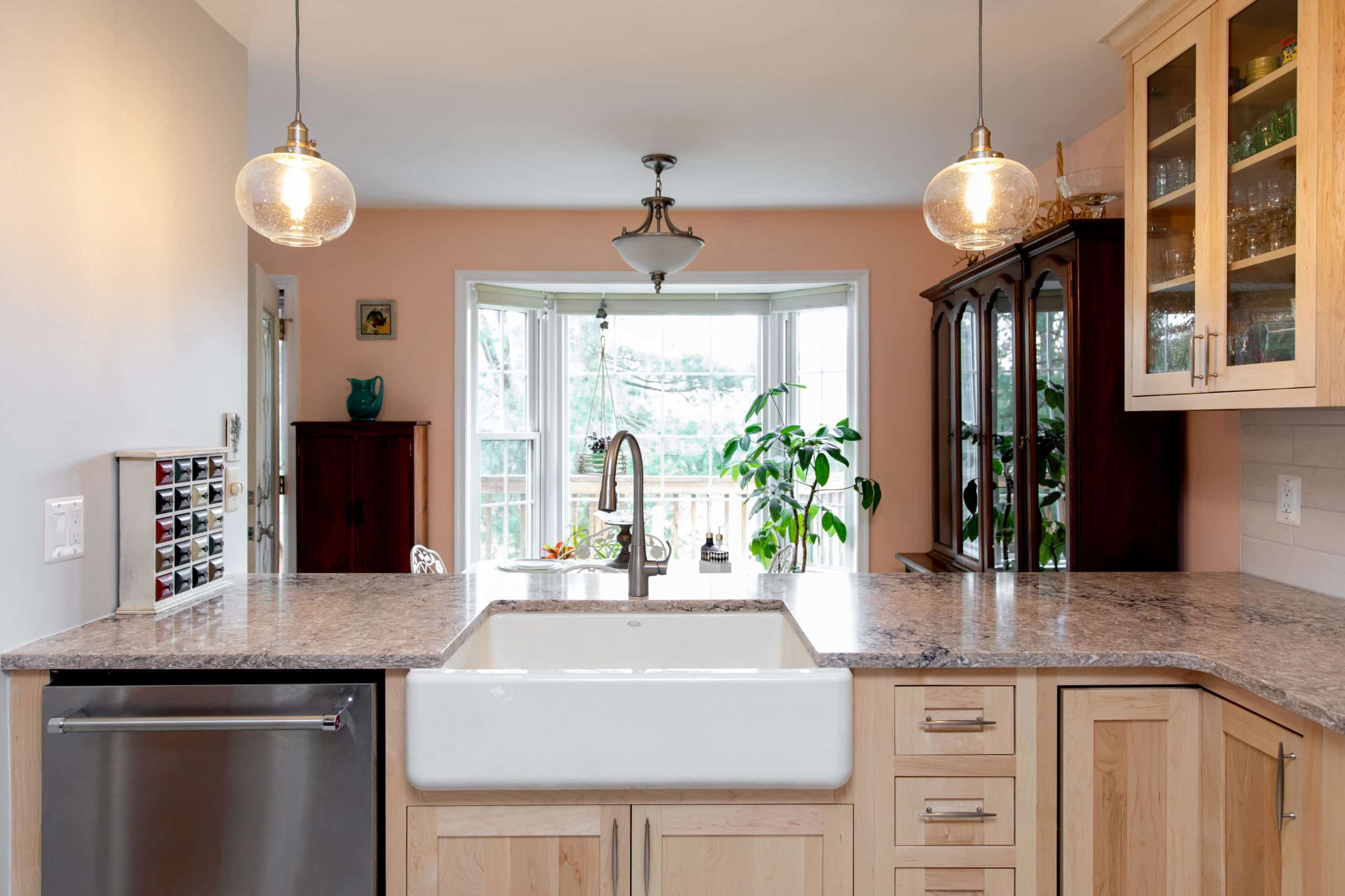 a kitchen with deep white sink, dishwasher and wooden cabinets