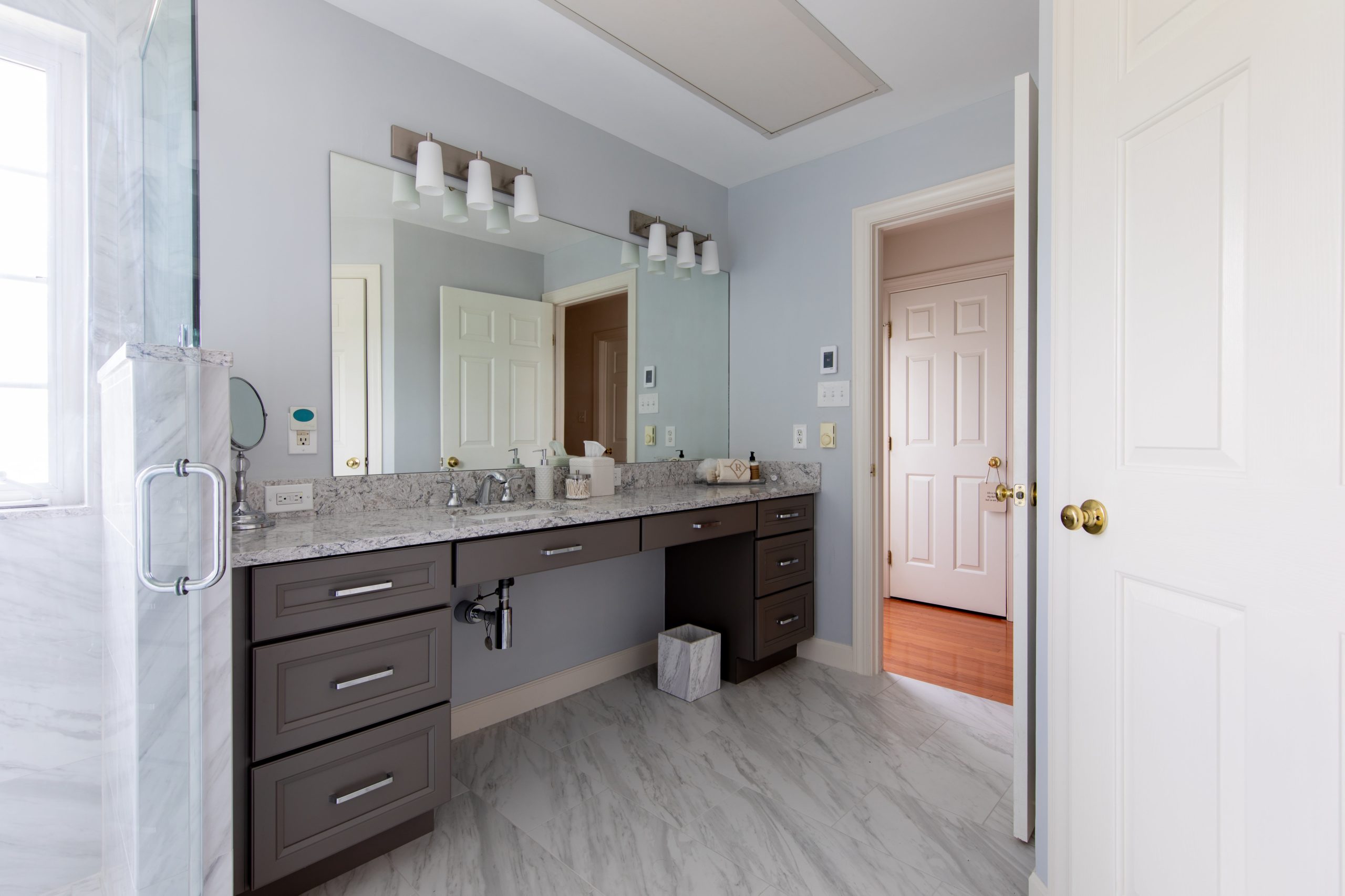a large bathroom with one sink, a larger mirror and blue walls