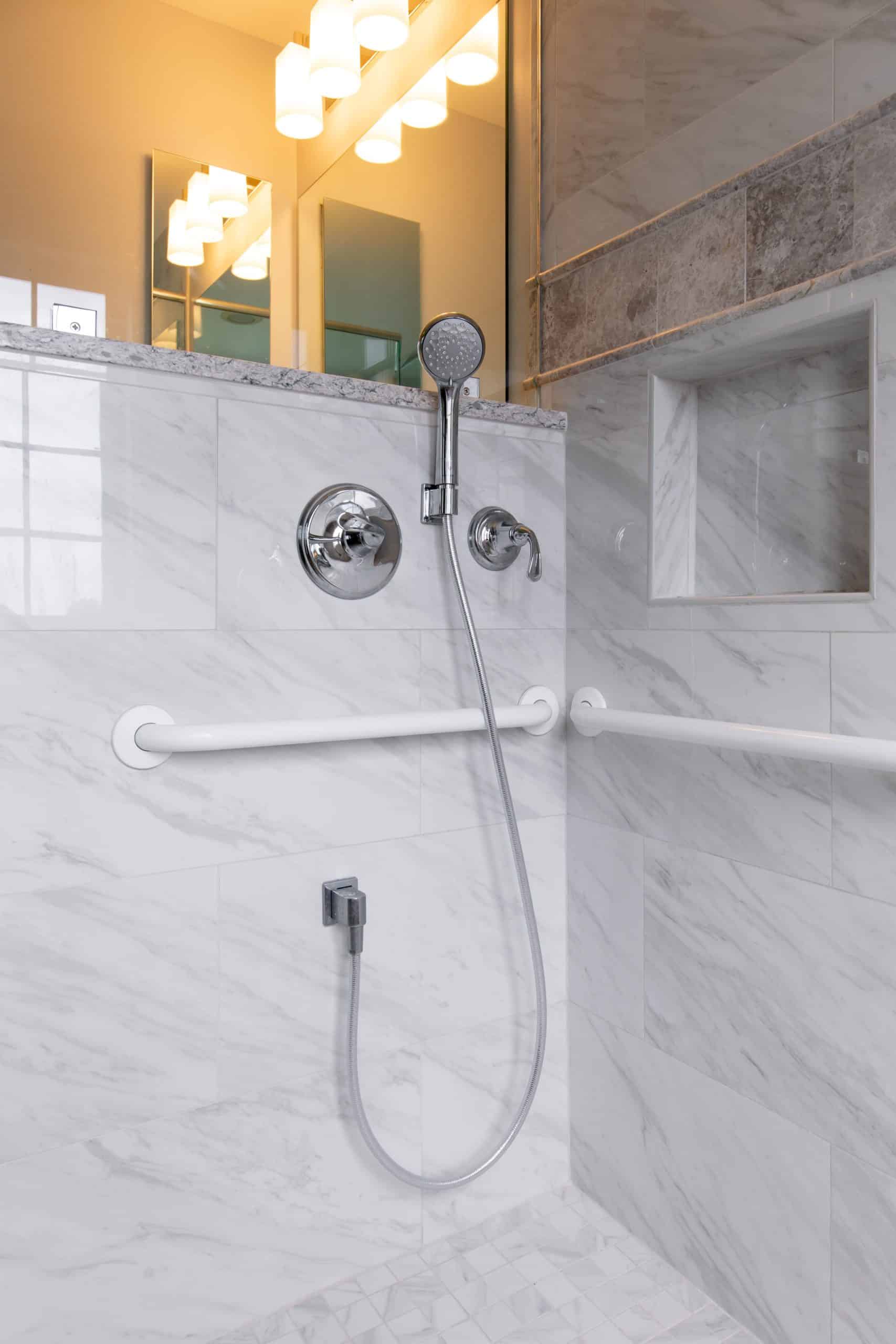 a bathroom with a shower head and hand rail