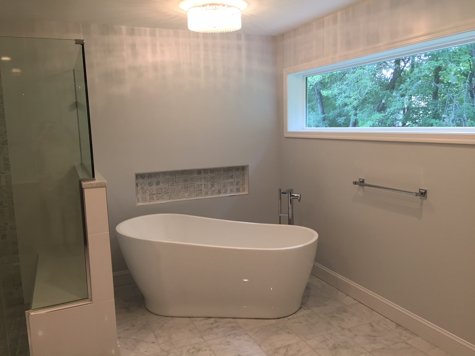 a bathroom with a standalone bathtub and shower in it